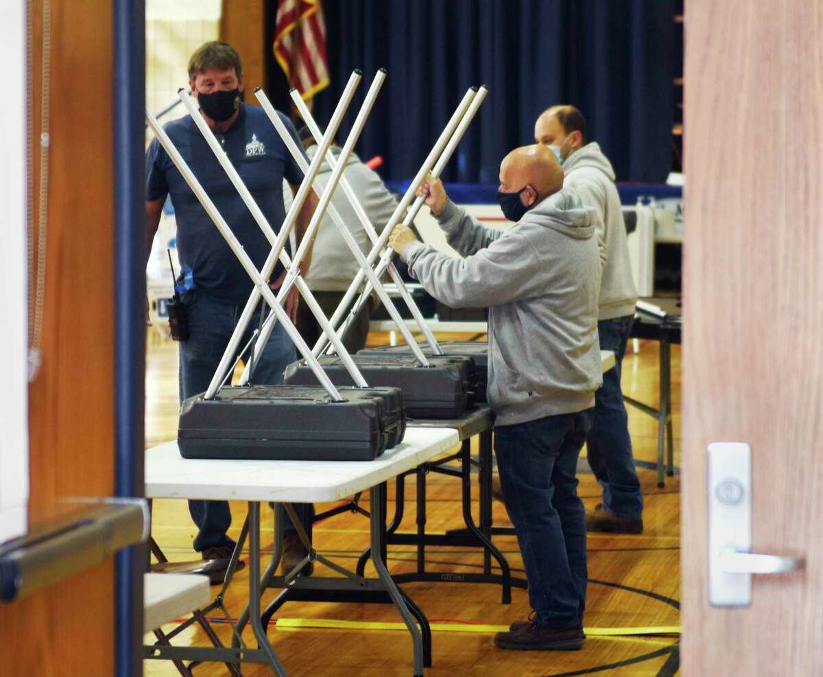 Public Works employees set up the District 12 polling station at North Mianus School in the Riverside section of Greenwich, Conn. Monday, Nov. 1, 2021. Greenwich voters will head to the polls Tuesday to decide the positions of First Selectman, Tax Collector, Town Clerk, and Constable, as well as spots on the Board of Estimate and Taxation, Board of Education, Representative Town Meeting, and Board of Assessment Appeals.