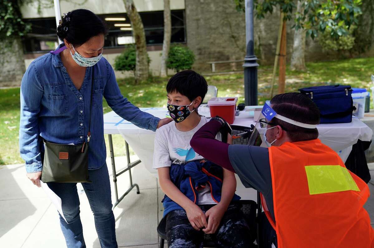 Colin Sweeney, 12, gets a shot of the Pfizer COVID-19 vaccine with his mother Nicole in May at a clinic in Pasadena.