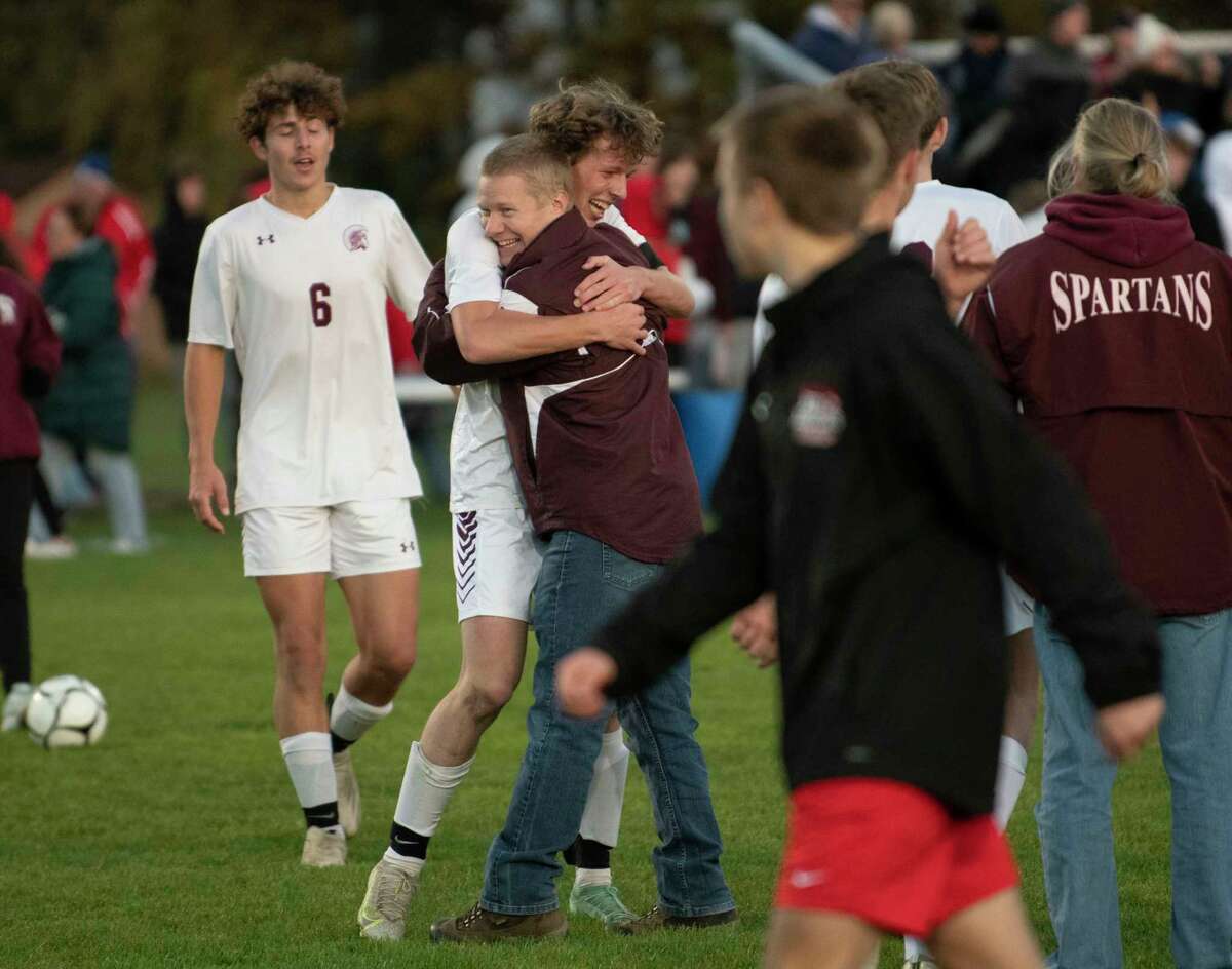Greenville head coach Nathan Forrest hugs Jack Motta as the team celebrates after defeating Mechanicville in the Class B boys' soccer final on Monday, Nov. 1, 2021 in Colonie, N.Y.