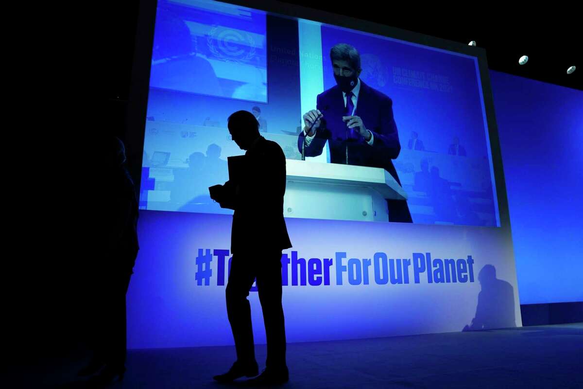 President Joe Biden walks off after speaking during an event about the "Global Methane Pledge" at the COP26 U.N. Climate Summit, Tuesday, Nov. 2, 2021, in Glasgow, Scotland, as John Kerry, United States Special Presidential Envoy for Climate is seen taking the podium, as shown on the screen. (AP Photo/Evan Vucci)