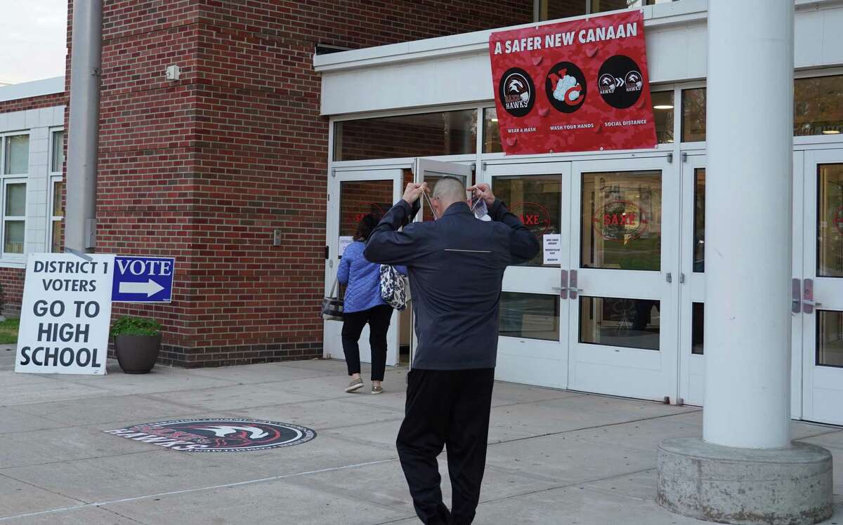 Voters must wear masks when the polling place is in a school. Unlike previous years, this year residents are entering through the front door of Saxe Middle School in New Canaan on Nov. 2.