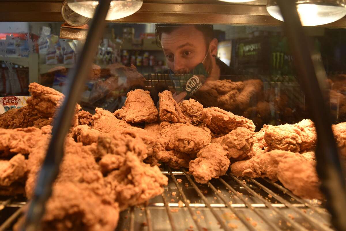 Stuart Schuffman, AKA Broke-Ace Stuart, reviews the fried chicken at the Gas and Shop on South Van Ness Avenue in San Francisco on Tuesday, November 2, 2021.
