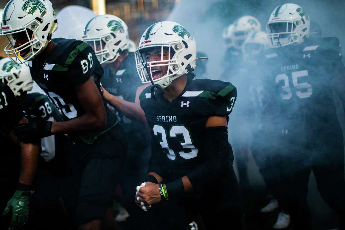 Spring High School Lions’ Trevis Montgomery and his team run out of the tunnel for a game against the Tomball Memorial High School football team at the Planet Ford Stadium, Thursday, Sept. 9, 2021, in Spring.