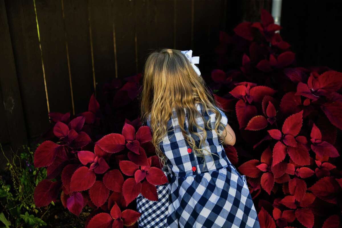 Hannah Spinner, 4, takes a look at plants she has planted with her family at their home’s backyard in Houston, Thursday, Oct. 28, 2021. Hannah was enrolled in the COVID-19 Pfizer vaccine study, but her parents and her don’t know if she got the vaccine or the placebo. On Hannah’s fifth birthday in two weeks, she will find out whether she got the real vaccine or a placebo and if she got the placebo, she will be eligible to get the real COVID-19 vaccine.