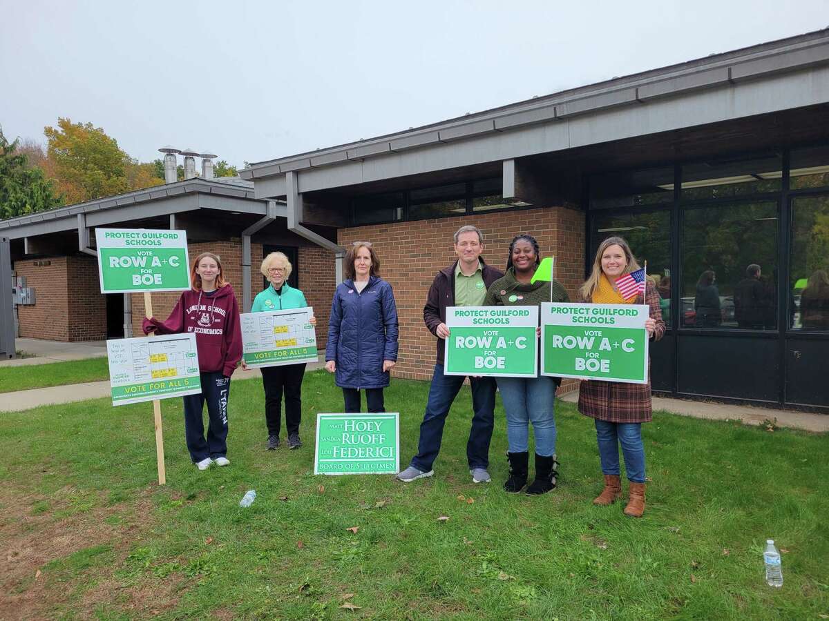 Candidate Kristy Faulkner, far right, stands with current Board of Education Chair Dr. Kathleen Balestracci, center, and supporters pose outside of polling place A.W. Cox Elementary School on Tuesday, Nov. 2, 2021.