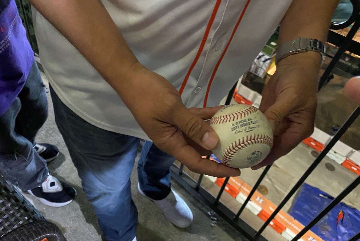 Manuel Ramos shows off the ball Jorge Soler hit out of the park at Game 6 of the World Series at Minute Maid Park on Nov. 2, 2021.