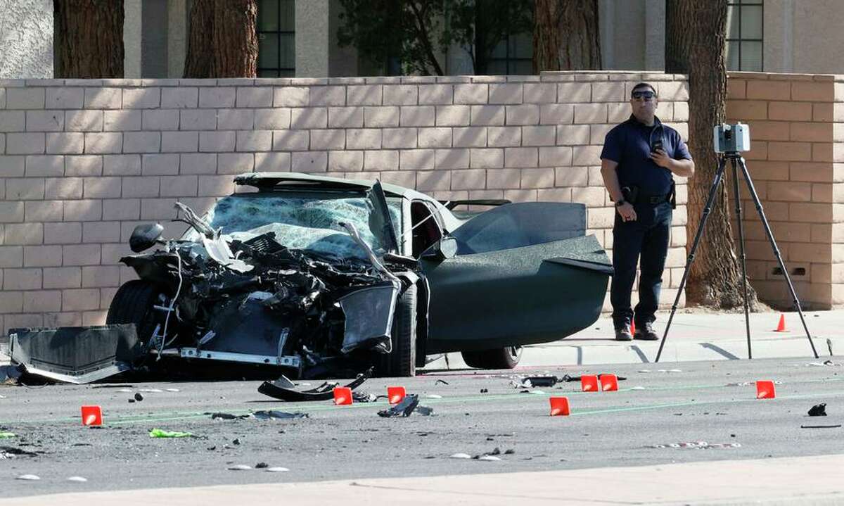 A crime scene investigator stands next to the Corvette involved in a fatal crash in Las Vegas on Wednesday.