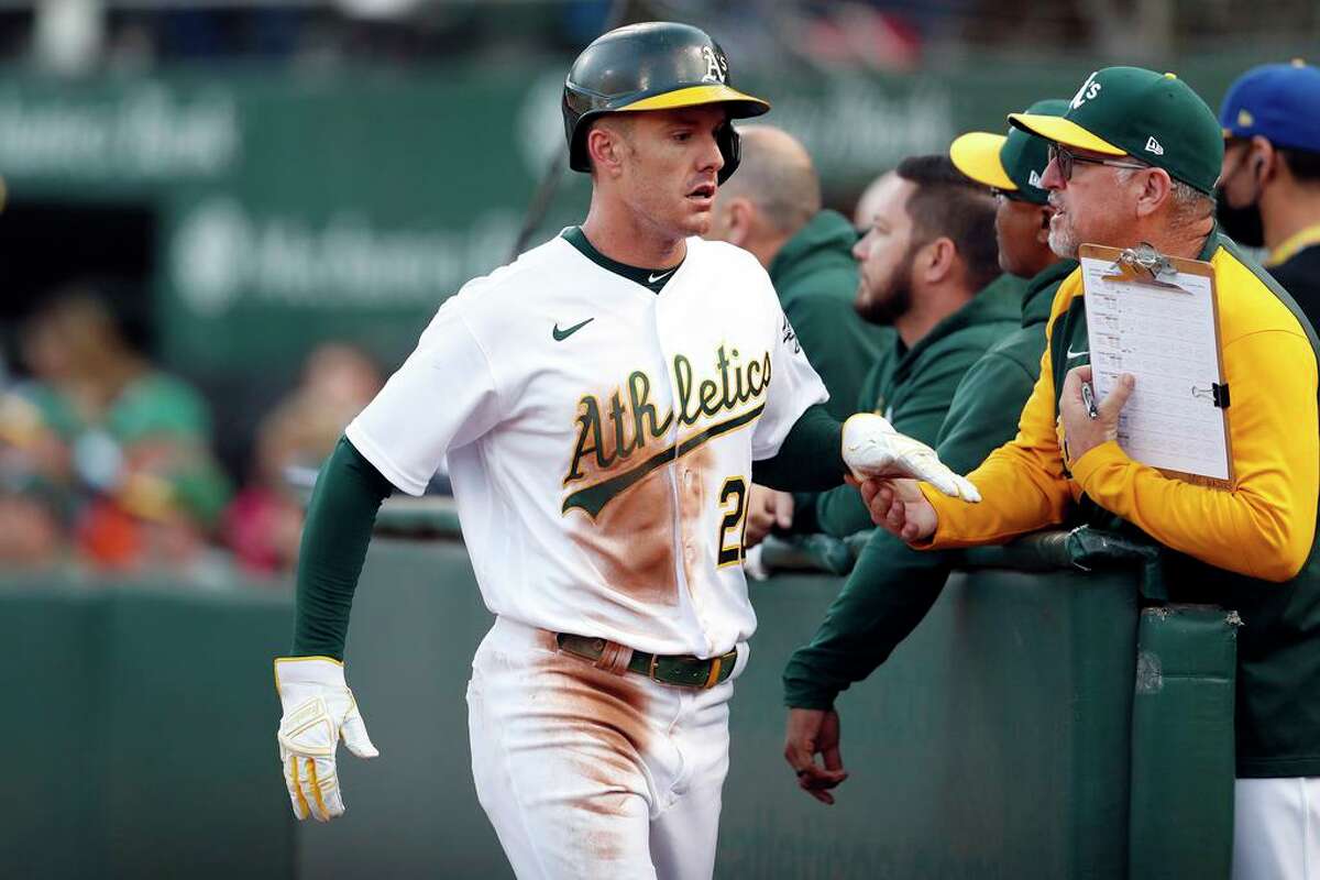 Oakland Athletics' Mark Canha returns to dugout after scoring on Yan Gomes' ground out in 1st inning against Seattle Mariners during MLB game at Oakland Coliseum in Oakland, Calif., on Monday, August 23, 2021.