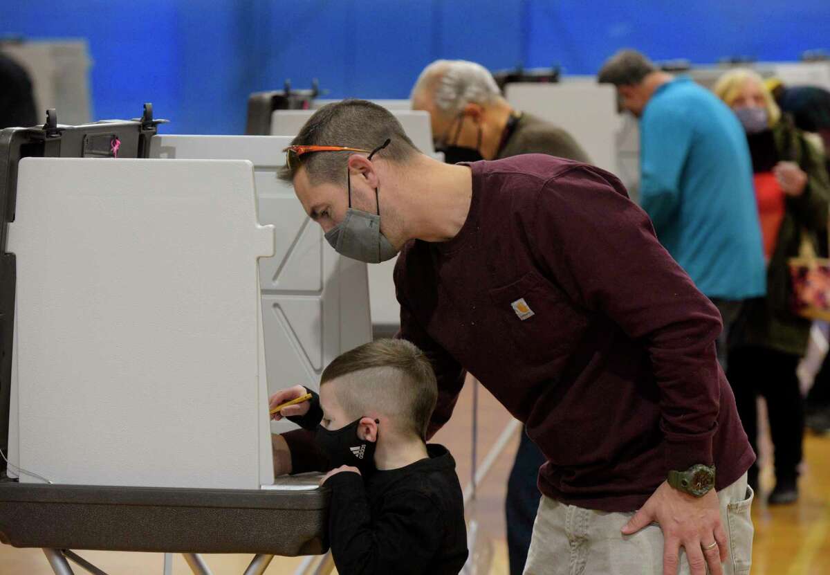 Bryson Grimm, age 5, was at the War Memorial gym in Danbury, Conn., on Tuesday afternoon, helping his father Kevin Grimm, of Danbury vote. November 2, 2021.