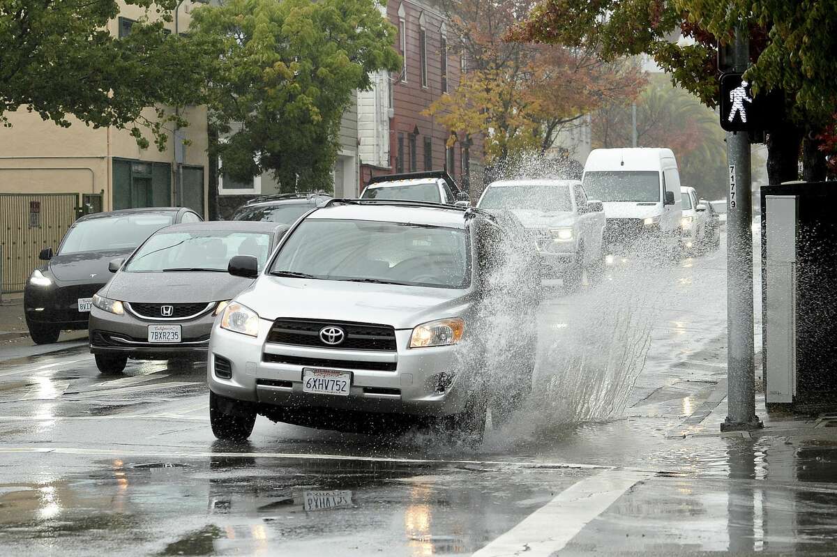 A car makes a big splash driving over a puddle on Third Street in San Rafael, Calif. on Thursday, Oct. 21, 2021.