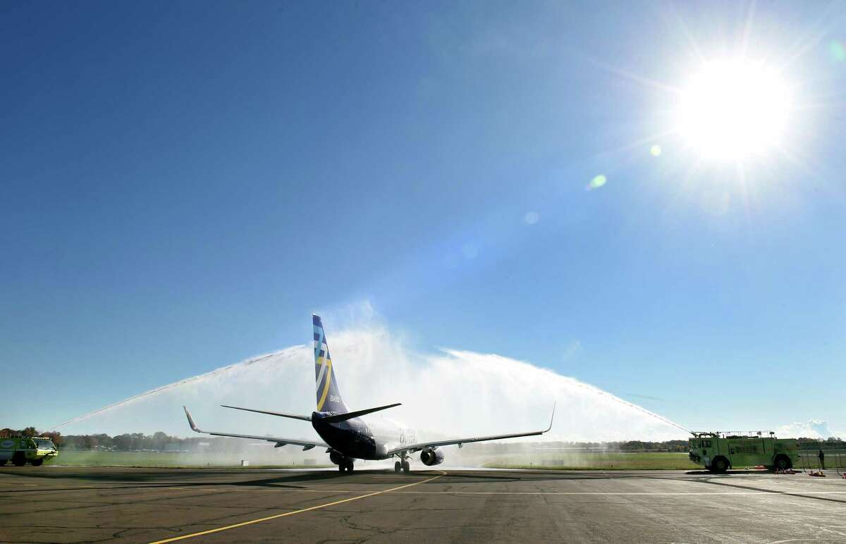 The Avelo Airlines inaugural flight from Tweed New Haven Regional Airport to Orlando is doused by water from firetrucks before departing on Nov. 3, 2021.