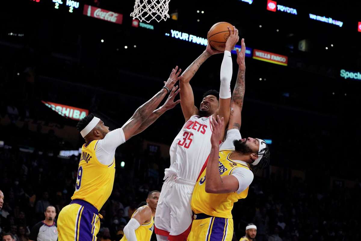 Houston Rockets center Christian Wood (35) shoots between Los Angeles Lakers forward Anthony Davis, right, and forward Kent Bazemore (9) during the second half of an NBA basketball game Tuesday, Nov. 2, 2021, in Los Angeles. (AP Photo/Marcio Jose Sanchez)