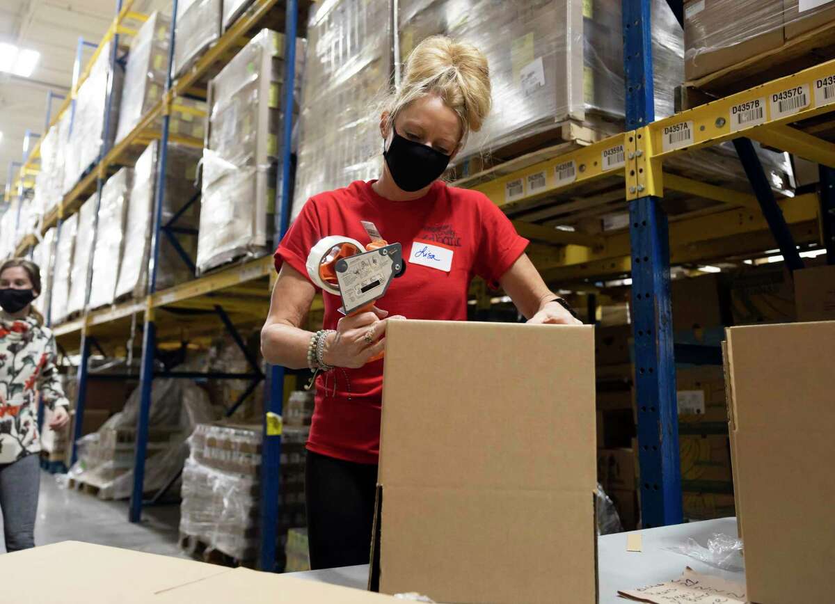 Lisa Akins packaged boxes during an event at the Montgomery County Food Bank in February in The Woodlands. Chef Jimmy Neill of the April Sound Country Club has helped the Montgomery County Food Bank with stories and recipes he wrote during the pandemic.