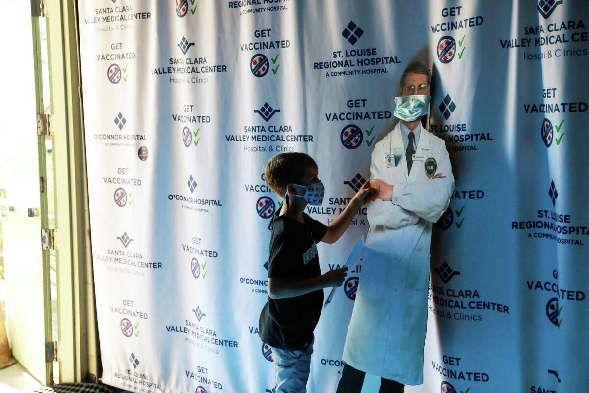 Finn Washburn, 9, greets a cutout of federal medical adviser Dr. Anthony Fauci after getting the coronavirus vaccine at Emmanuel Baptist Church in San Jose.