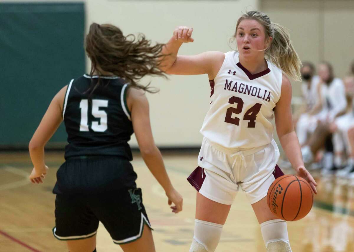 Magnolia guard Claire McCusker (24) makes a call to her teammates as she dribbles the ball under pressure from Kingwood Park guard Aliyah Bustamante (15) during the second quarter of a Region III-5A girls basketball bi-district game at The Woodlands High School, Friday, Feb. 12, 2021, in The Woodlands.