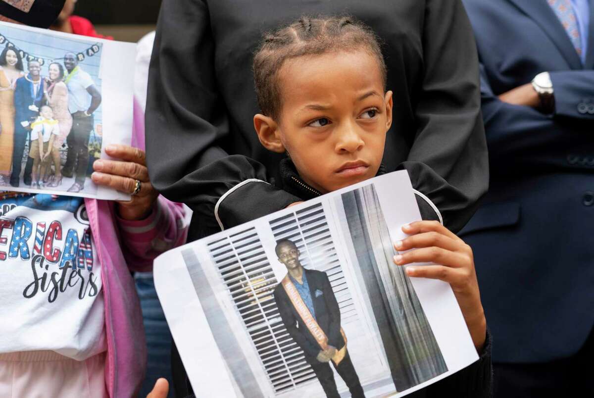 Dallas Garcia stands with her son Jagger, 7, as he holds a picture of his older brother, Fred Harris, during a press conference, Wednesday, Nov. 3, 2021, outside of the Harris County Jail in Houston. Fred Harris, who had special needs and who had no prior arrests, is currently unconscious waiting for his organs to be harvested after being stabbed and beaten by another inmate at the Harris County Jail.