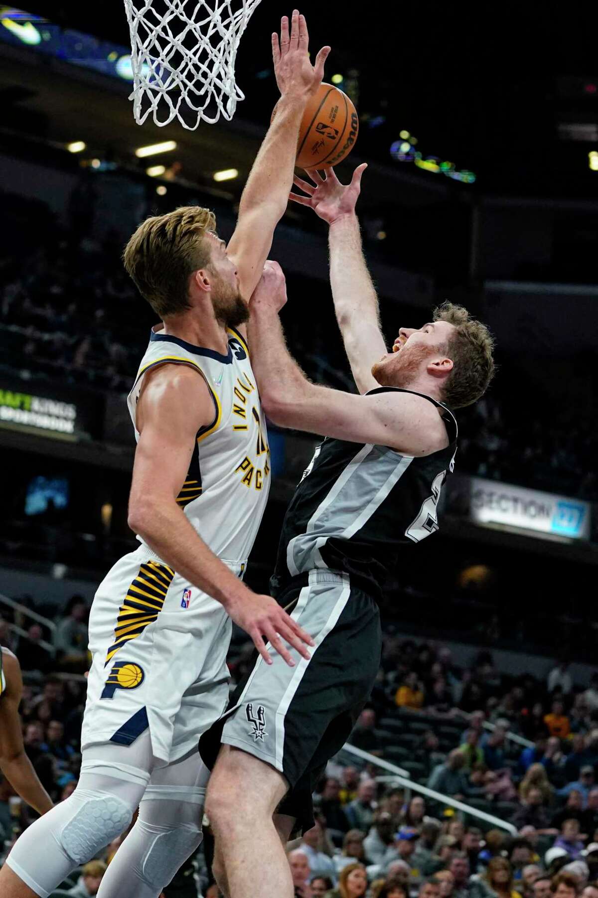 Jakob Poeltl, right, is likely to miss multiple games for the Spurs while awaiting clearance from COVID-19 protocols.