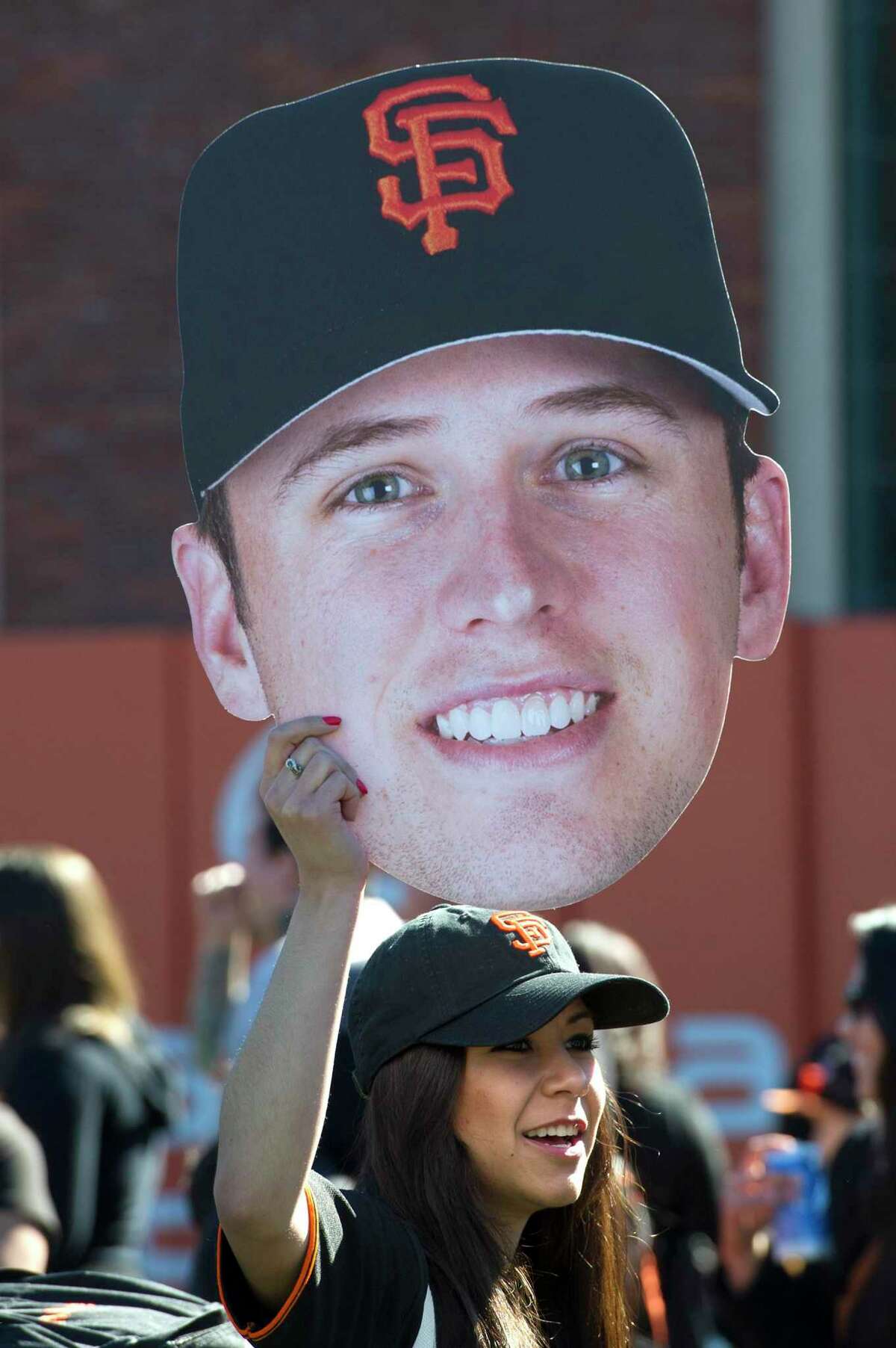 Lily Castillo holds a giant photo of Buster Posey aloft during fan appreciation day at then-AT&T Park in San Francisco on Feb. 9, 2013.