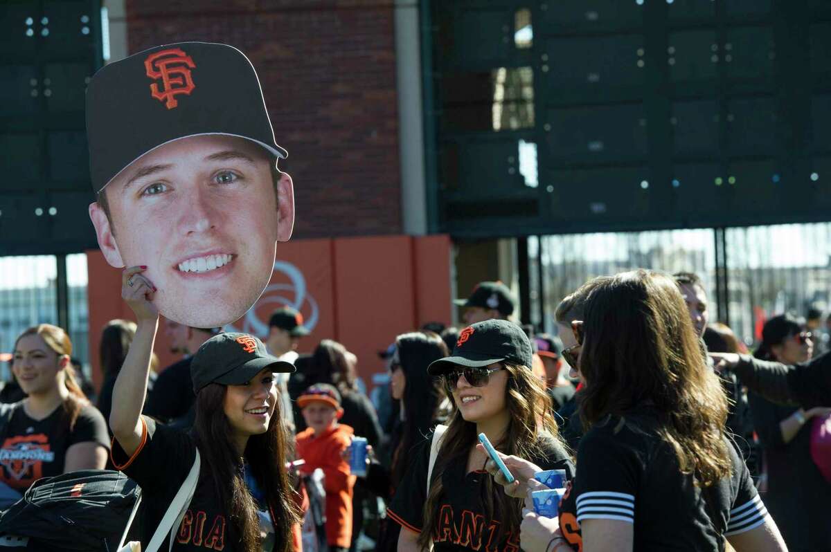 Lily Castillo, 19, left, holds up a photograph of Giants catcher Buster Posey as Yolanda Castillo, 21 Olivia Birdwell, 19 and Samantha Peters look on during fan appreciation day at AT&T Park in San Francisco, Calif., on Saturday, Feb. 9, 2013.