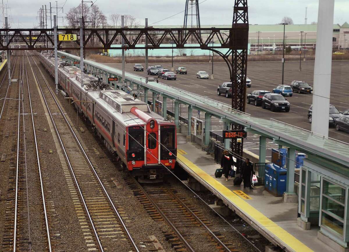 A pair of riders exit an afternoon Metro North train out of New York at the Fairfield Metro station in Fairfield, Conn. on Wednesday, March 25, 2020.