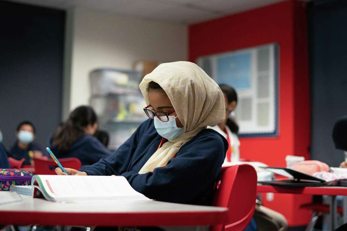 Eighth-grade student Nawf Abuelgasim participates in Algebra lessons in the classroom at AIMS School in Oakland. She says some students are struggling to speak with one another again.