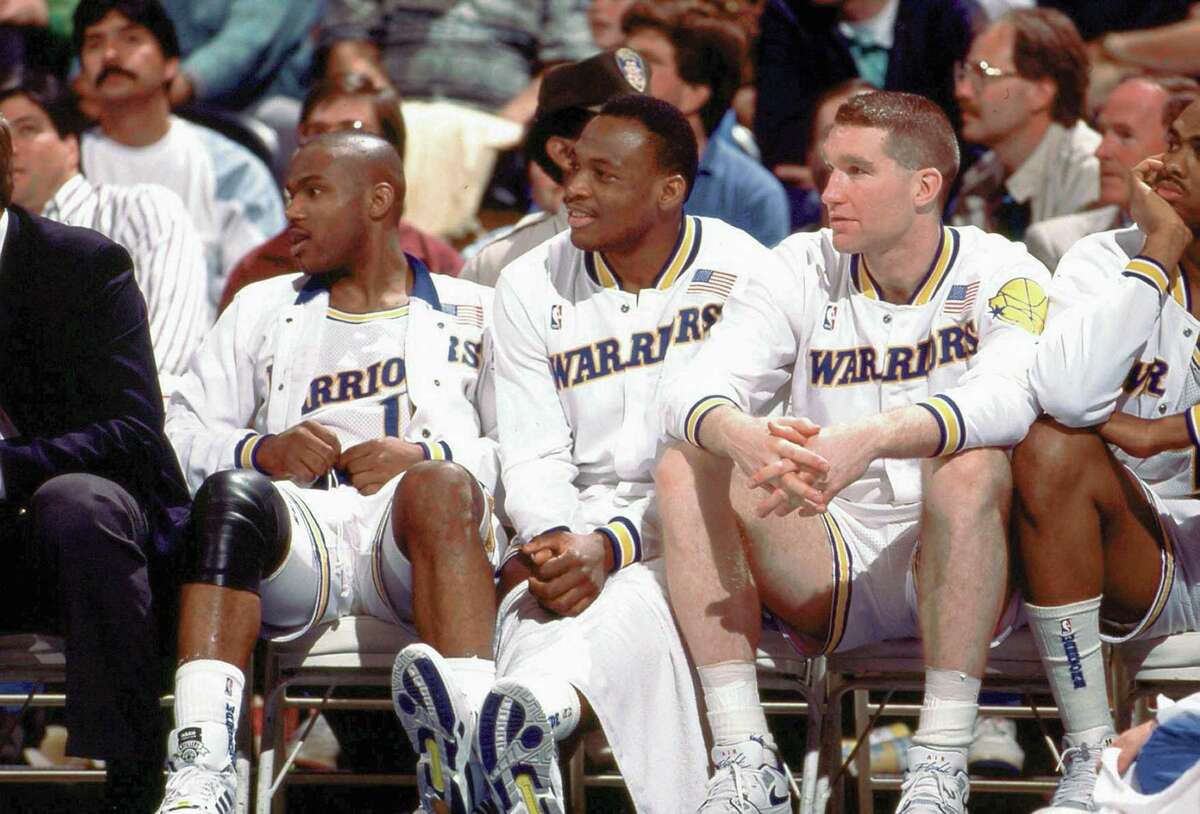 OAKLAND, CA - 1989: (L) Tim Hardaway #10, (C) Mitch Richmond #23 and (R) Chris Mullin #17 of the Golden State Warriors sit on the bench during a game played in 1989 at the Oakland-Alameda Coliseum in Oakland, California. NOTE TO USER: User expressly acknowledges that, by downloading and or using this photograph, User is consenting to the terms and conditions of the Getty Images License agreement. Mandatory Copyright Notice: Copyright 1989 NBAE (Photo by NBA Photos/NBAE via Getty Images)
