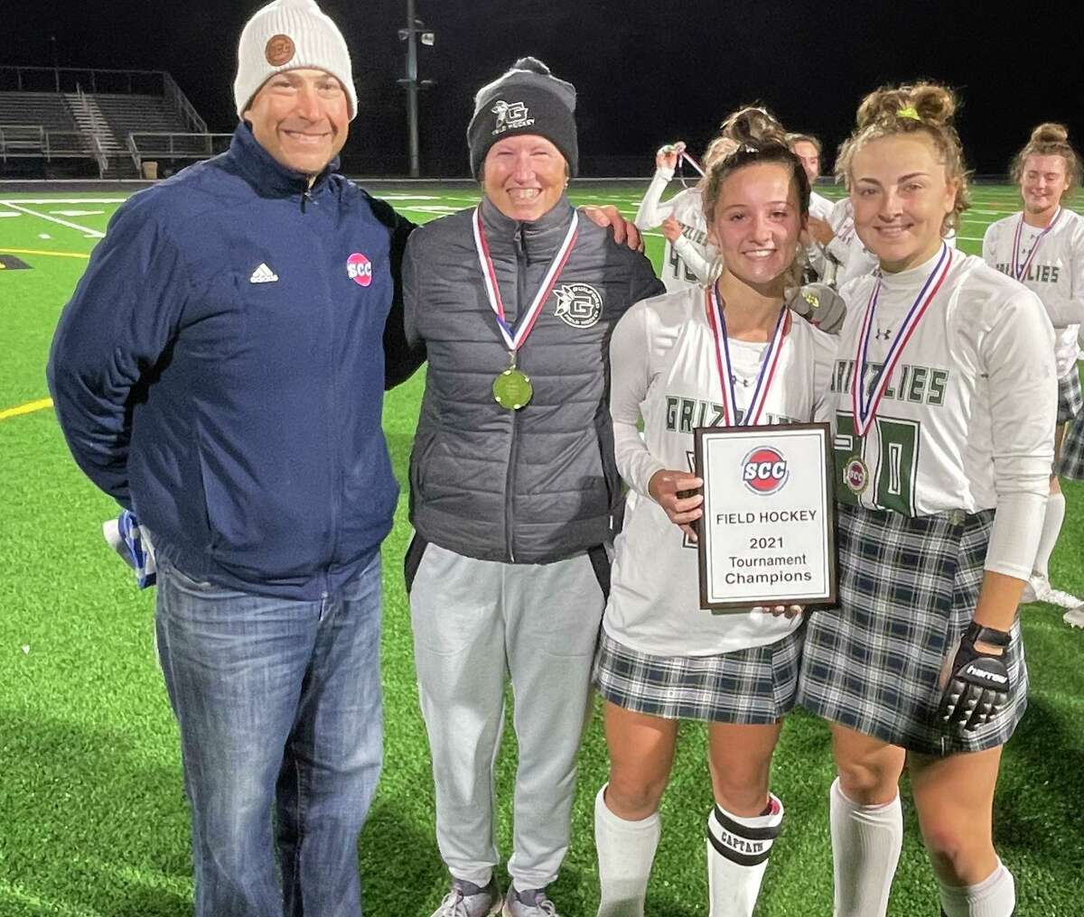 Guilford coach Kitty Palmer and captains along with SCC Commissioner Al Carbone after the Grizzles won the SCC field hockey championship Wednesday.