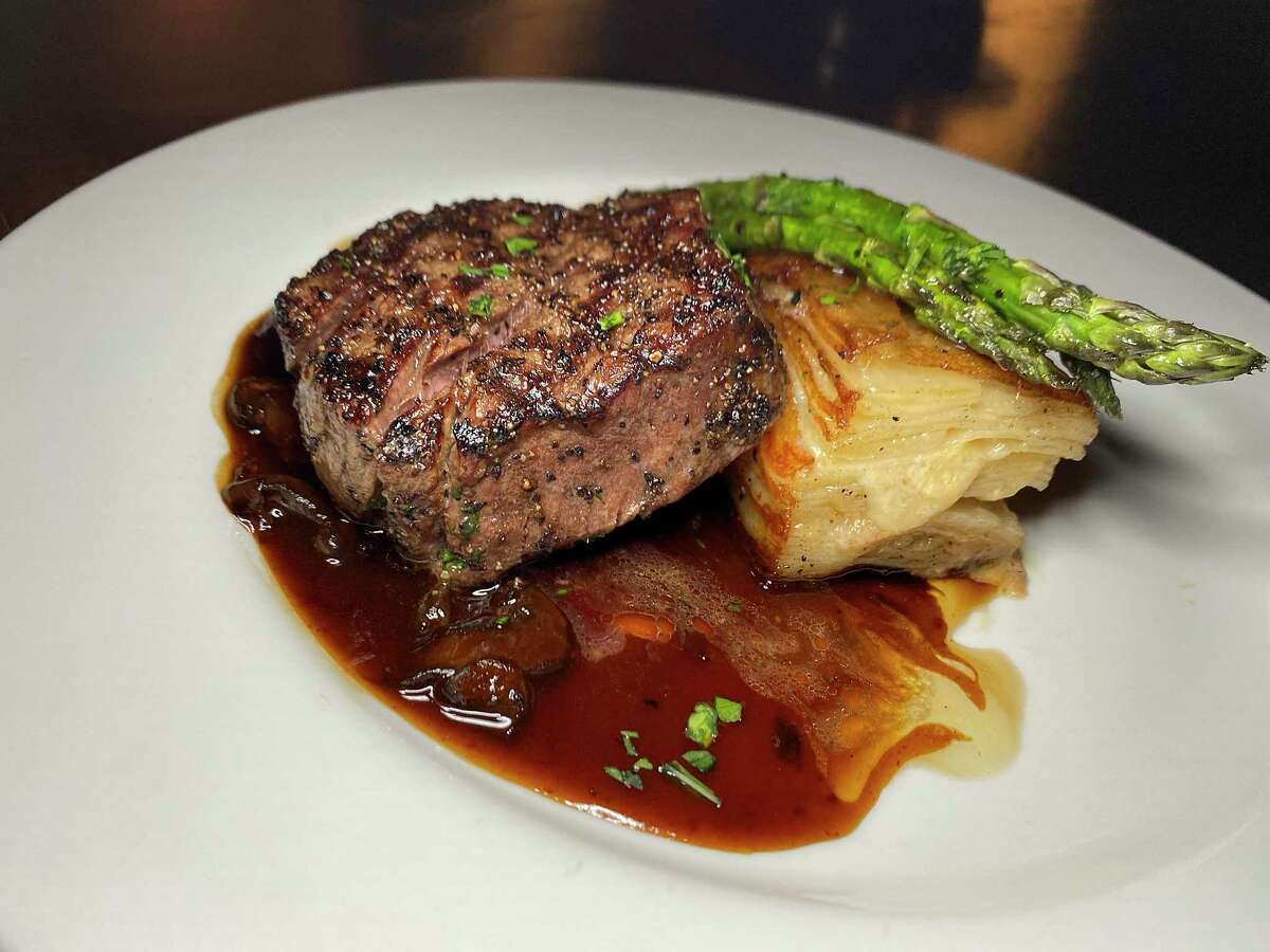 Pepper-crusted tenderloin is served with potato gratiné and asparagus with red wine mushroom demi-glace at Bar Loretta, a new restaurant in the King William Historic District.