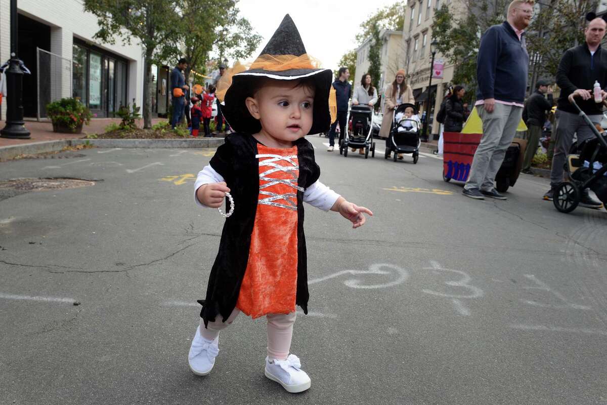 Dressed as a witch, 1-year old Georgiana Small walks in the children’s Halloween parade.