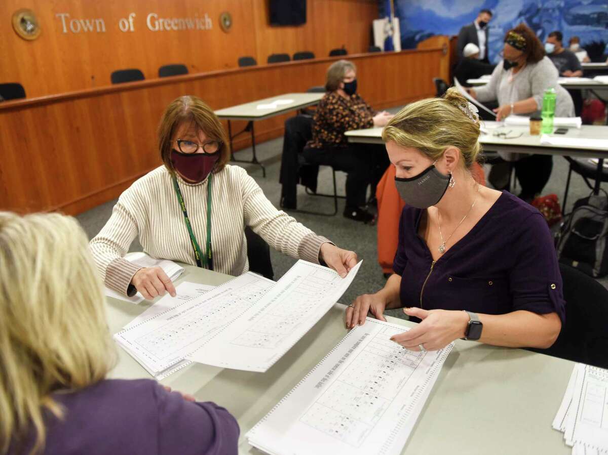 Town employees Tina Corlett, left, and Jennafer Kalna recount ballots at Town Hall in Greenwich, Conn. Thursday, Nov. 4, 2021. An all-day effort was underway Thursday to recount the Greenwich school board race separated by only 36 votes