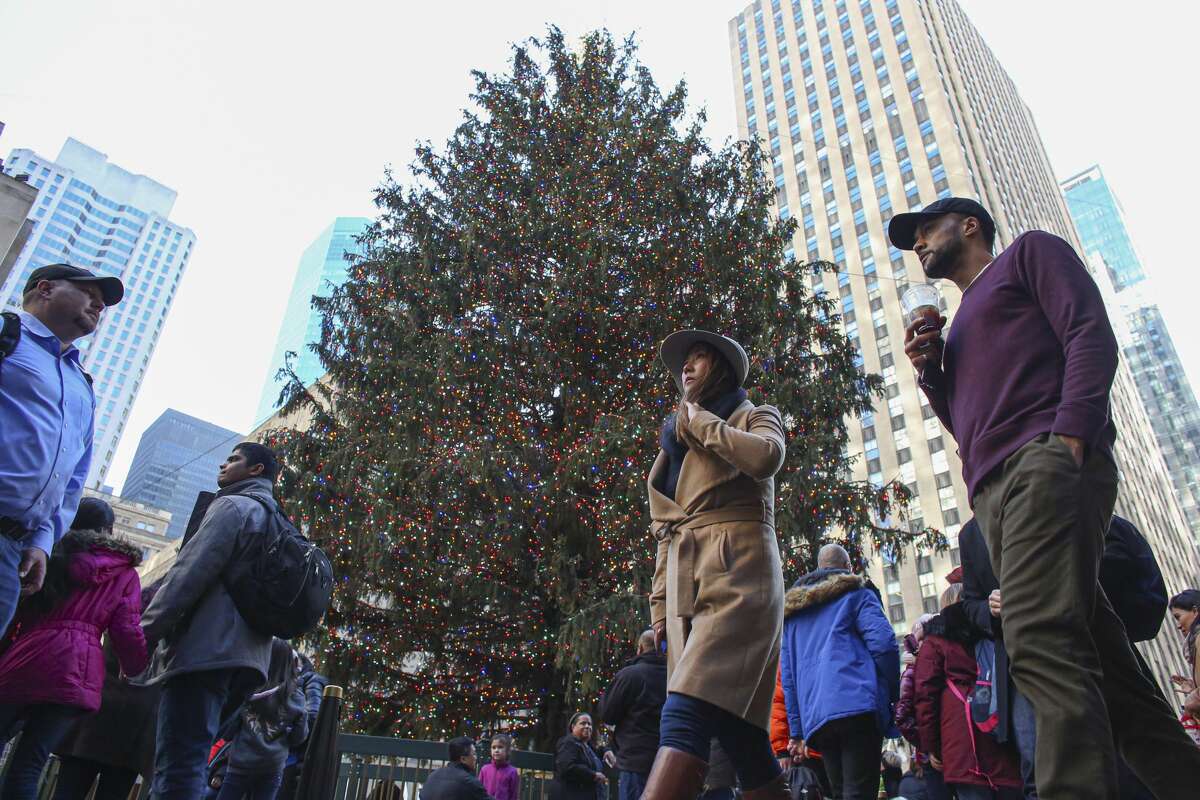 People walk pass by the Christmas tree at Rockefeller center on December 23, 2019 in New York City. In 2019, the 77-foot Norway Spruce came from the Hudson Valley, cut down in the Town of Florida in Orange County. This year the tree is coming from Maryland.
