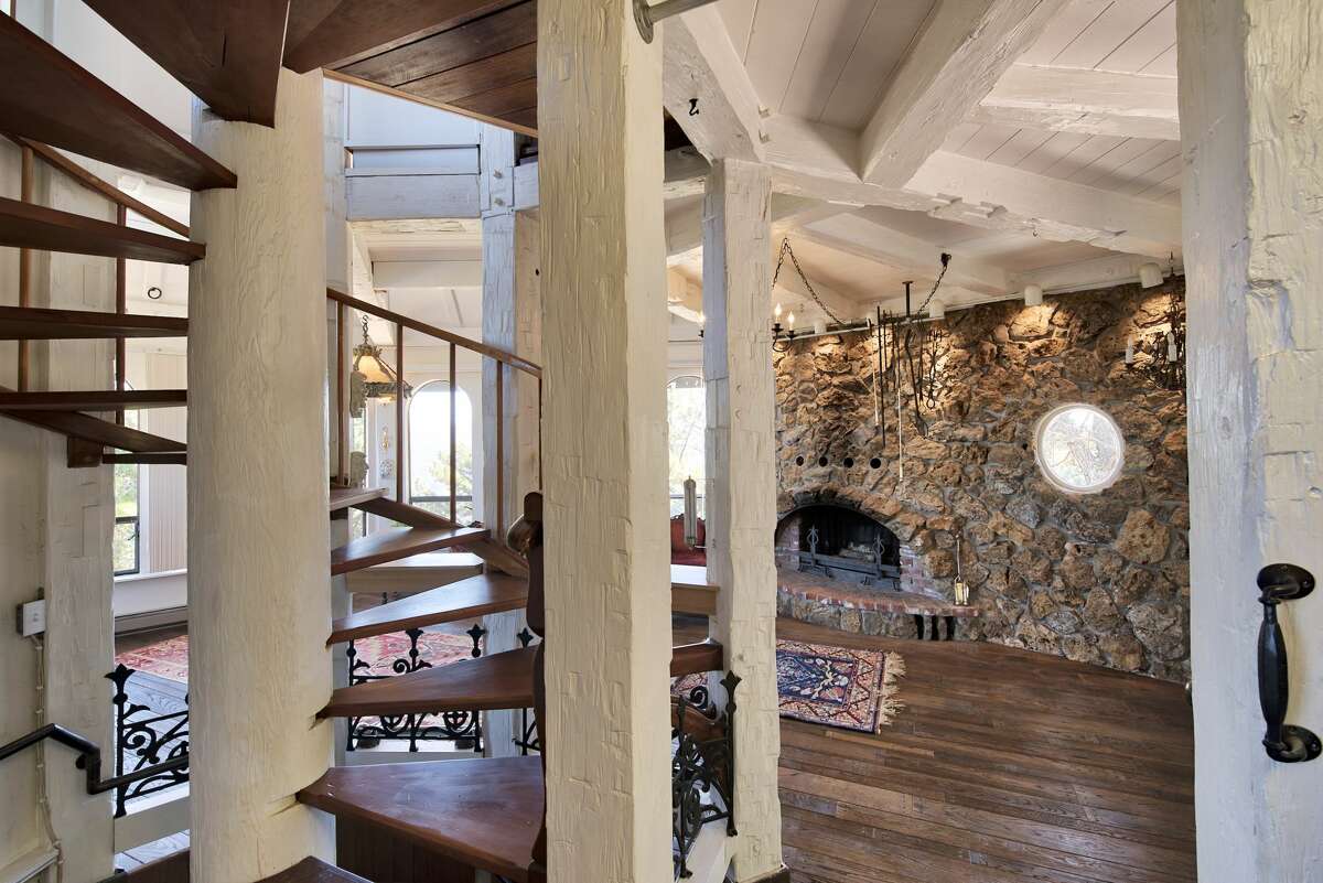 Inside we see those redwood beams, now painted, and stone walls opening for a natural fireplace.