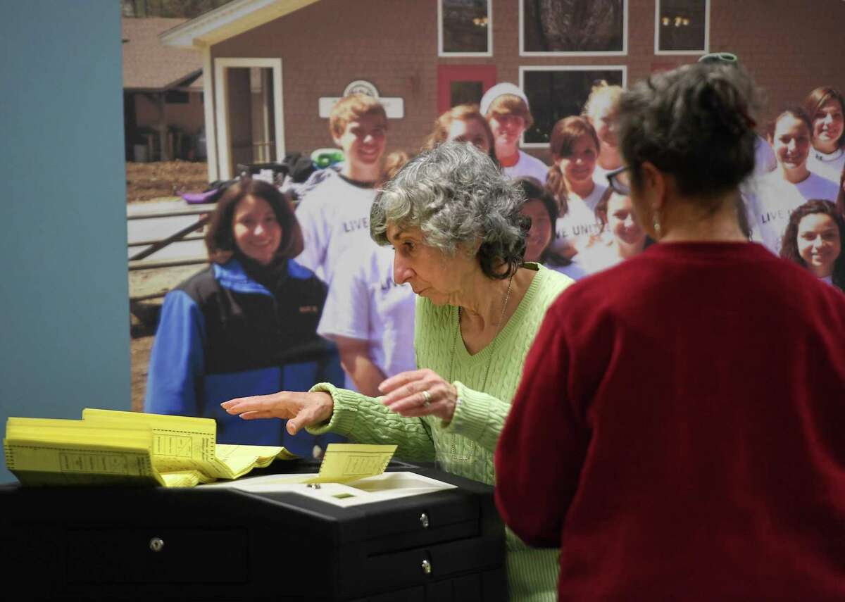 Head Counter Joann Luchen inserts ballots through a counter during the counting of absentee mail-in ballots at the Registrar's Office at the Richard O. Belden Center in Shelton, Conn. on Thursday, November 4, 2021.