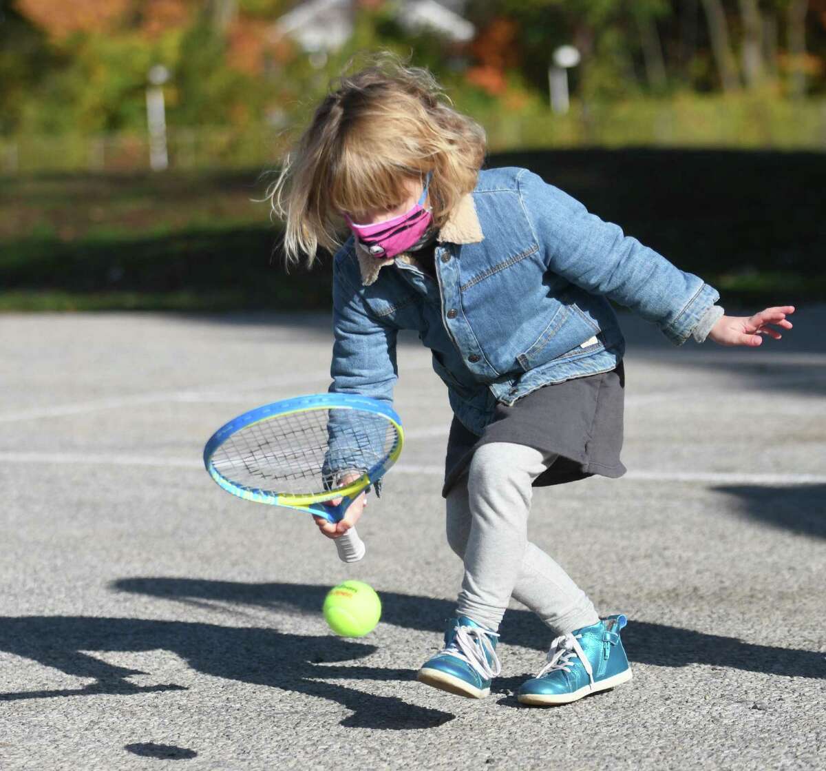 Kindergartner Lily Hagstrom practices bouncing the ball during former tennis pro Eric Butorac's class for students at Cos Cob School in the Cos Cob section of Greenwich, Conn. Thursday, Nov. 4, 2021. The former tennis doubles specialist lives in Cos Cob and his children attend school in Greenwich, so he took a day to teach tennis to kids during gym class at Cos Cob School. The students learned the basics of tennis and completed drills individually and in small groups.