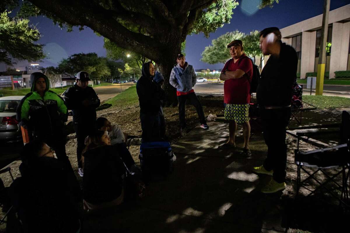A group of immigrants who recently arrived recently to the United States wait outside of the Immigration and Customs Enforcement Houston Field Office at midnight holding their turn to check in with ICE, Thursday, Oct. 28, 2021, in Houston. Accompanying them is some of the members of the FIEL Houston’s leadership.