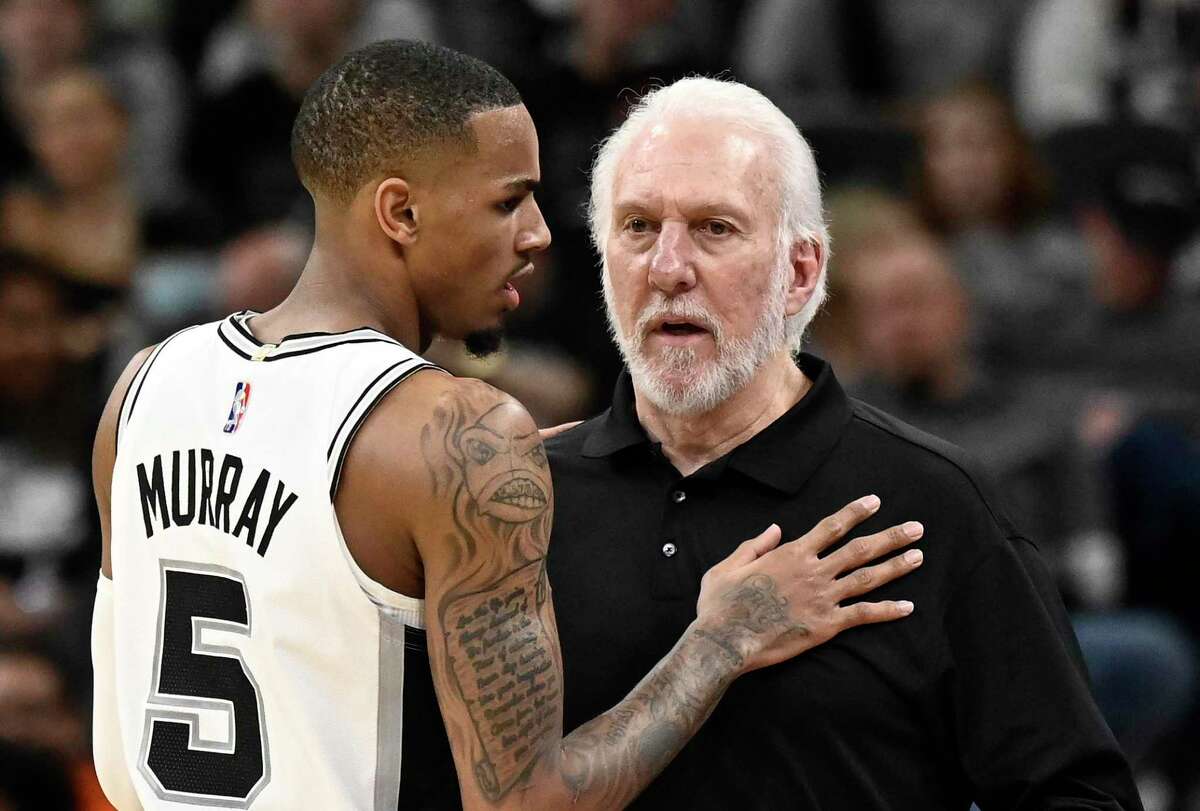 San Antonio Spurs coach Gregg Popovich, right, talks with guard Dejounte Murray during the first half of the team's NBA basketball game against the Dallas Mavericks on Wednesday, Nov. 3, 2021, in San Antonio.