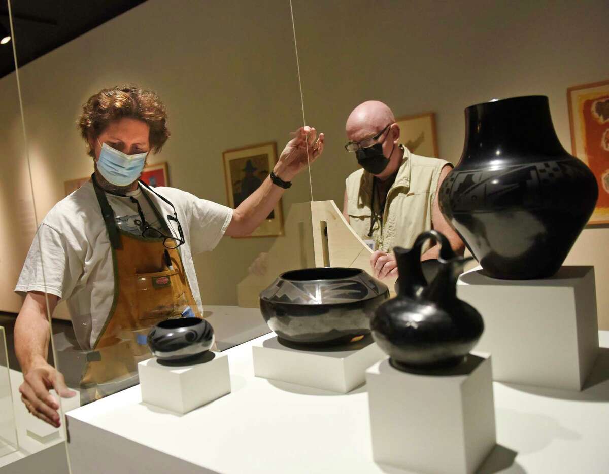 Exhibition Preparator Sean Murtha, left, and Senior Exhibition Designer Dan Buckley encase Native American blackware pottery at the new exhibit "Resolute: Native Nations Art in the Bruce Collection" at the Bruce Museum in Greenwich, Conn. Wednesday, Nov. 3, 2021. The Bruce Museum is opening two new exhibitions on Nov. 7. "Resolute: Native Nations Art in the Bruce Collection" features significant objects that provide new information about Native Nations as historical and contemporary societies."The Fisher Dollhouse: A Venetian Palazzo in Miniature" features miniature renderings of 10 rooms inside a diorama inspired by Venice's glamorous Gritti Palace.