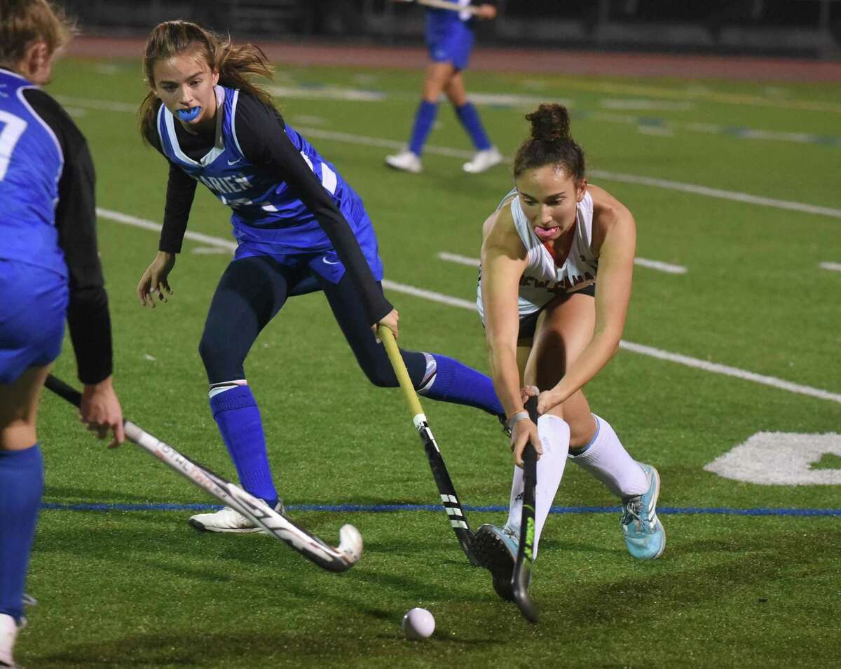 New Canaan's Shawna Ferraro (4) plays the ball while Darien's Ashley Stockdale (13) defends during the FCIAC field hockey final in Norwalk on Thursday, Nov. 4, 2021.
