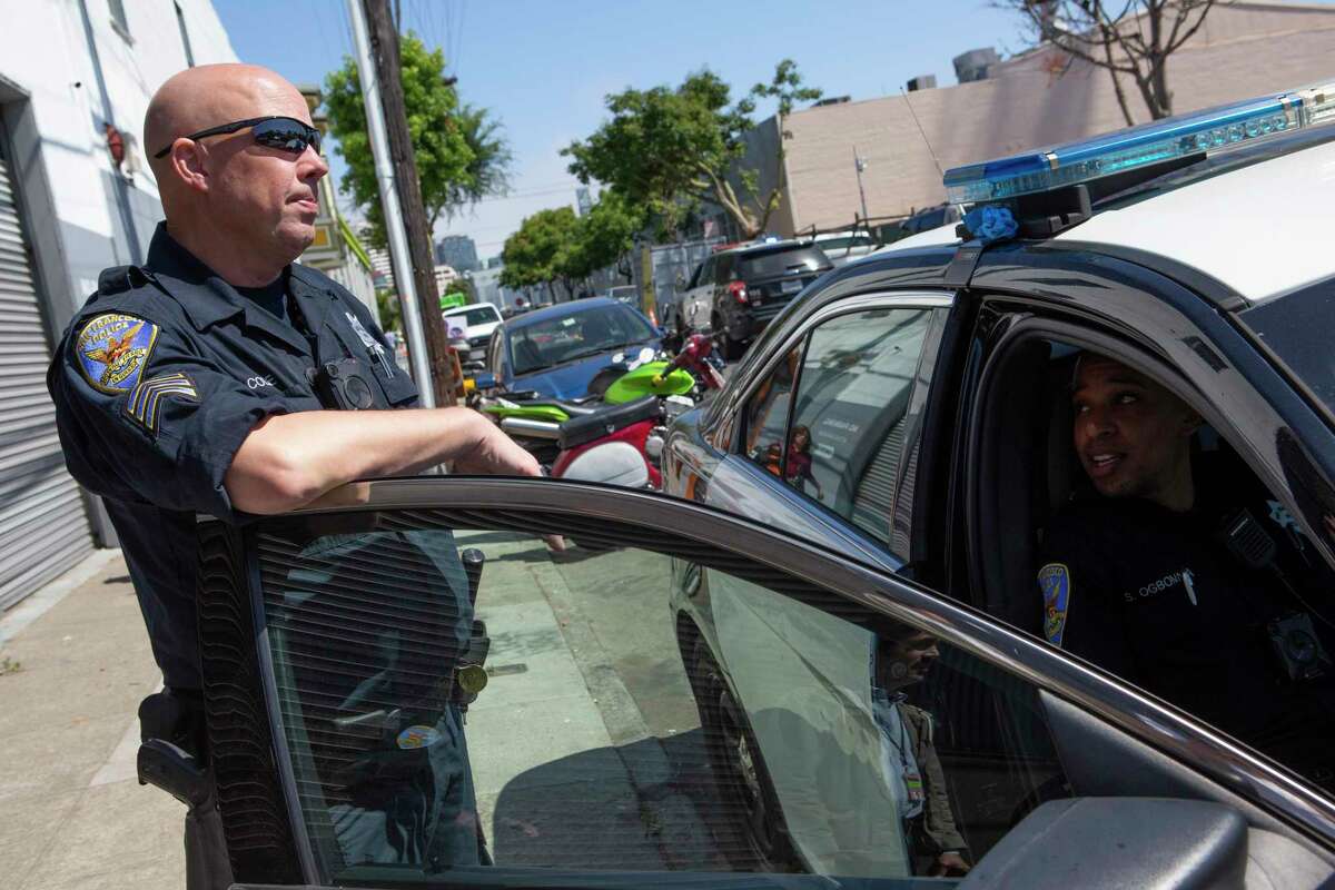 San Francisco Sgt. Davin Cole (left) and Officer Steven Ogbonna respond to a 311 call about an encampment in 2019. Cole was arrested on Wednesday on suspicion of robbing a Rite Aid in San Mateo.