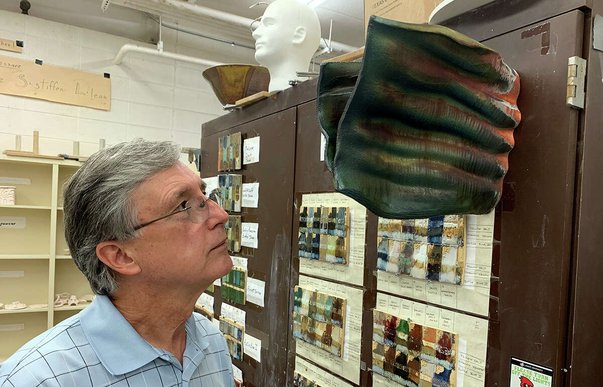 Linnis Blanton looks at one of his ceramic sculptures which is designed to hang on the wall. Photo by Andy Coughlan