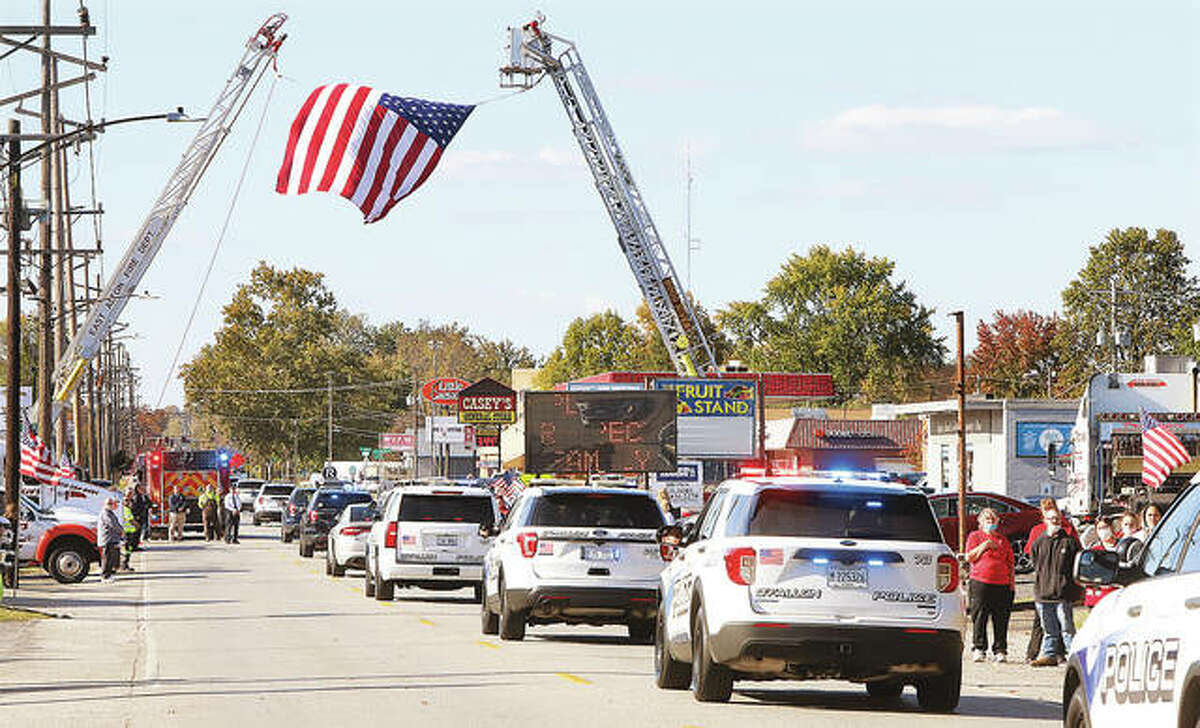 The funeral procession for slain Pontoon Beach Police Officer Tyler Timmins nears the end of its journey from Collinsville on Edwardsville Road at George Street in Wood River Tuesday.