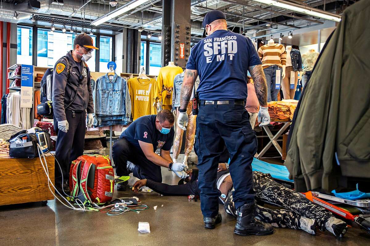 Emergency personnel with the San Francisco Fire Department prepare to inject a dose of Naloxone on an unconscious patient in San Francisco, California Thursday, Oct. 28, 2021.