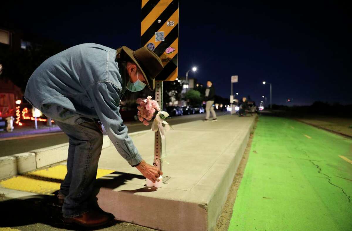 Michael Freed lights a candle Wednesday on Shore Line Drive, where Alameda County Supervisor Wilma Chan was killed by a motorist earlier in the day.