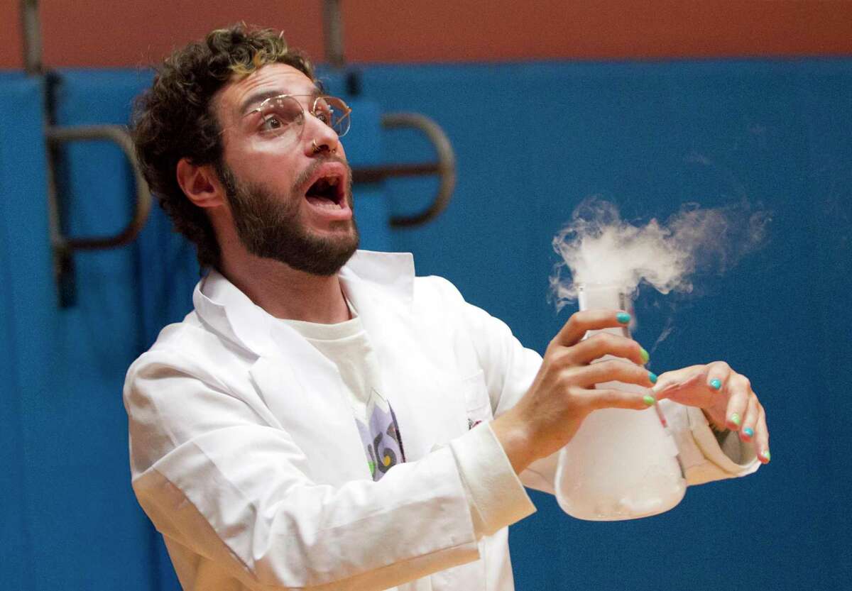 Brian Pagani reacts after a rubber stopper under pressure is shot across the gym during his Mad Science "Fire & Ice" Show for second graders at Cos Cob School in Greenwich, Conn., on Friday November 5, 2021. The Science Enrichment Committee planned the interactive science show, bringing back Brian's show for a second time. The students were in awe as they witnessing dragon breath, a fire cannon, combustion, dry ice geysers and other cool science experiments.