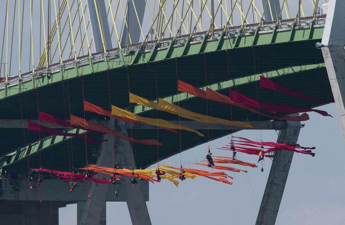 Eleven Greenpeace USA protesters are dangling from the northbound of the Fred Hartman Bridge to protest against the oil industry on Thursday, Sept. 12, 2019, in Baytown. Another 11 spotter for those protesters are sitting on the bridge. Protestors said they are intending to protest for 24 hours.