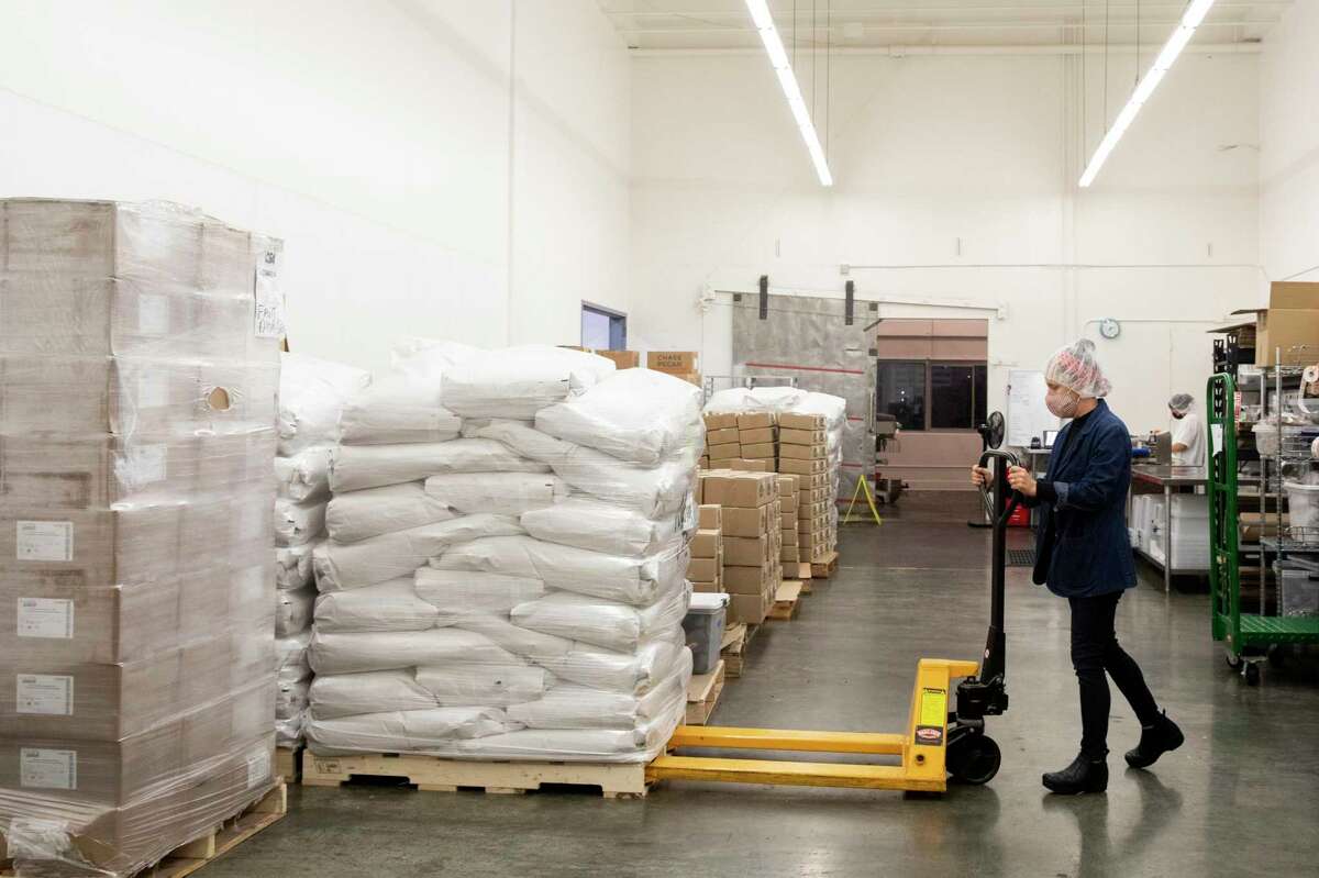 Nana Joe's Granola founder Michelle Pusateri organizes pallets of oats and other ingredients at their production facility in San Francisco, Calif. Wednesday, November 3, 2021. Nana Joe's Granola is seeing price rises and supply shortages because of the supply chain crisis and global warming affecting agricultural crops.