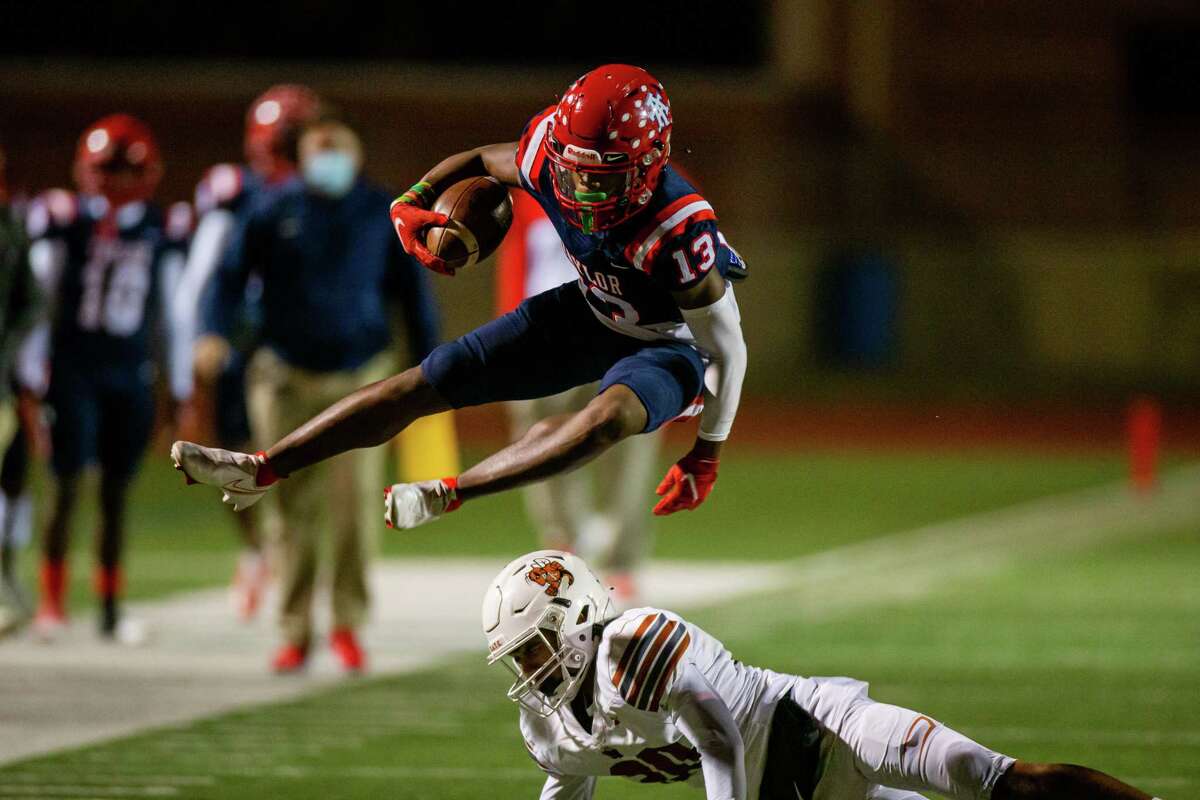 Alief Taylor WR Terrance Naulings (13) leaps over Alvin Yellowjackets LB Trevor Yarborough (30) during the first half of action between Alvin at Alief Taylor High School during a District 23-6A high school football game at Crump Stadium, Friday, November 5, 2021, in Houston. (Juan DeLeon/Contributor)