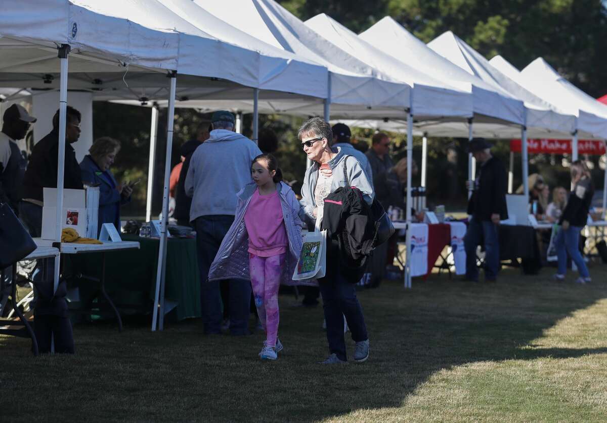 Guests visits vendors with packets of seeds during The Woodlands Flower Festival at Rob Flemming Park, Saturday, Nov. 6, 2021, in The Woodlands. The event benefited The Woodlands Lion Clubâs charities.