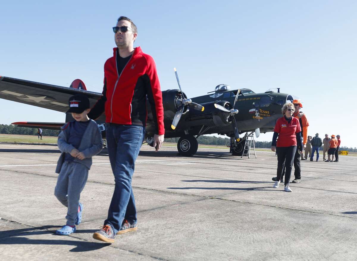 Peter Hochstaetter, center, takes his son, Pearson, to see other planes after touring a B-17 Flying Fortress at Conroe? S General Aviation Services on Saturday, November 6, 2021. Guests were able to tour and pay for trips in three local base planes, one of which