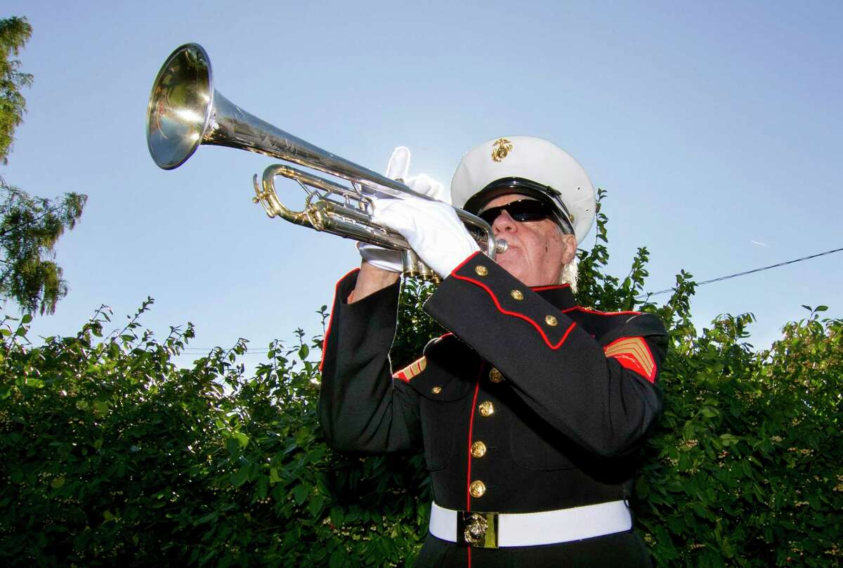 Cos Cob VFW Post 10112 bugler George Bennett plays taps during its annual Veterans Day event in the Cos Cob Pocket Park on Strickland Road in Greenwich, Conn., on Saturday November 6, 2021.